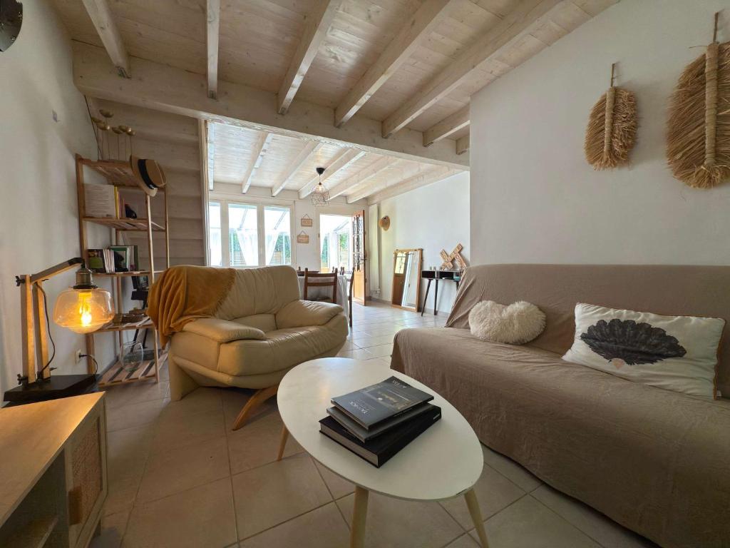 un salon avec un canapé et une table dans l'établissement Valras-Loc Grande maison familiale, à Valras-Plage