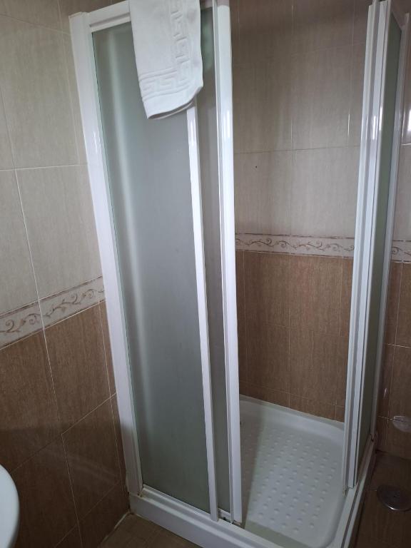 a shower with a glass door in a bathroom at Hostal Cafetería Restaurante Astigi in Almendral