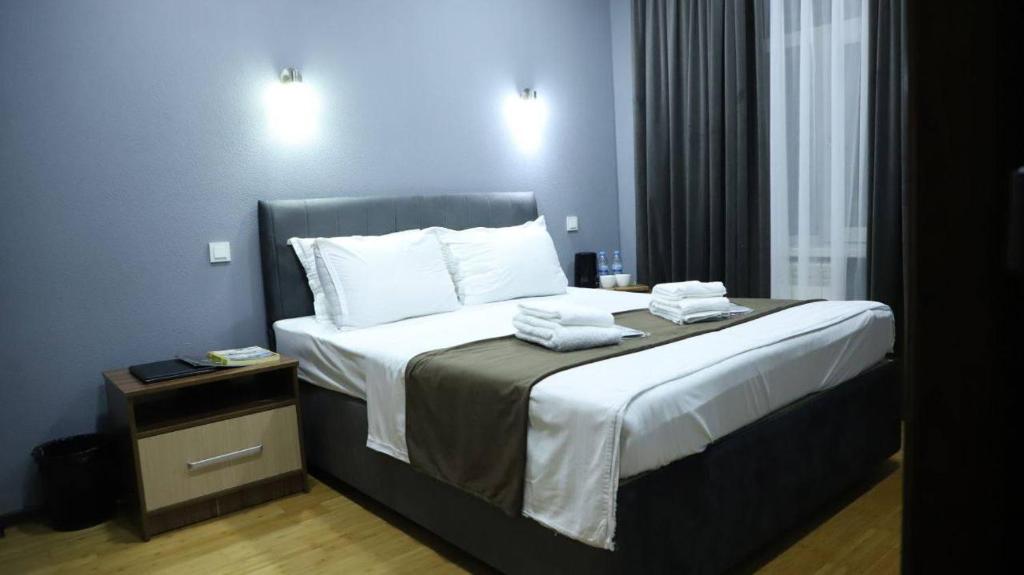 una camera d'albergo con un letto con asciugamani sopra di Старый Город гостница a Tashkent
