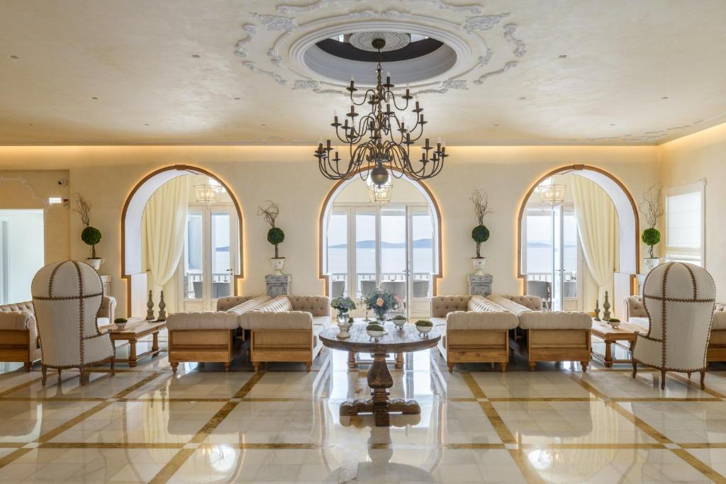 uma sala de estar com um lustre e uma mesa e cadeiras em Saint John Hotel Villas & Spa em Agios Ioannis Mykonos