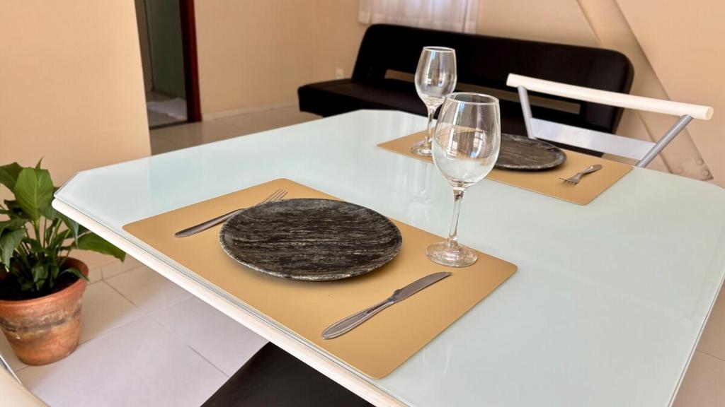 a white table with two glasses and a plate on it at 600m da UFV e 100m da rodoviária in Viçosa