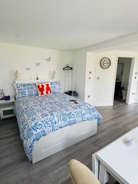a bedroom with a bed with blue and red pillows at The Garden Room in Torquay