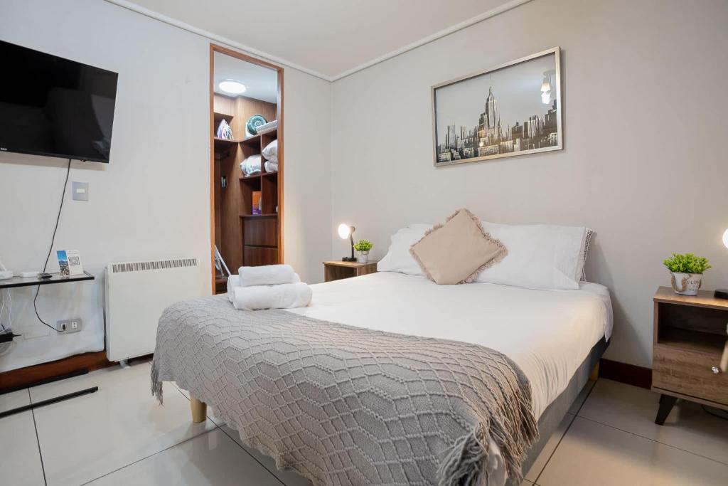 a bedroom with a bed and a flat screen tv at Delightful Studio Apartment in Las Condes in Santiago