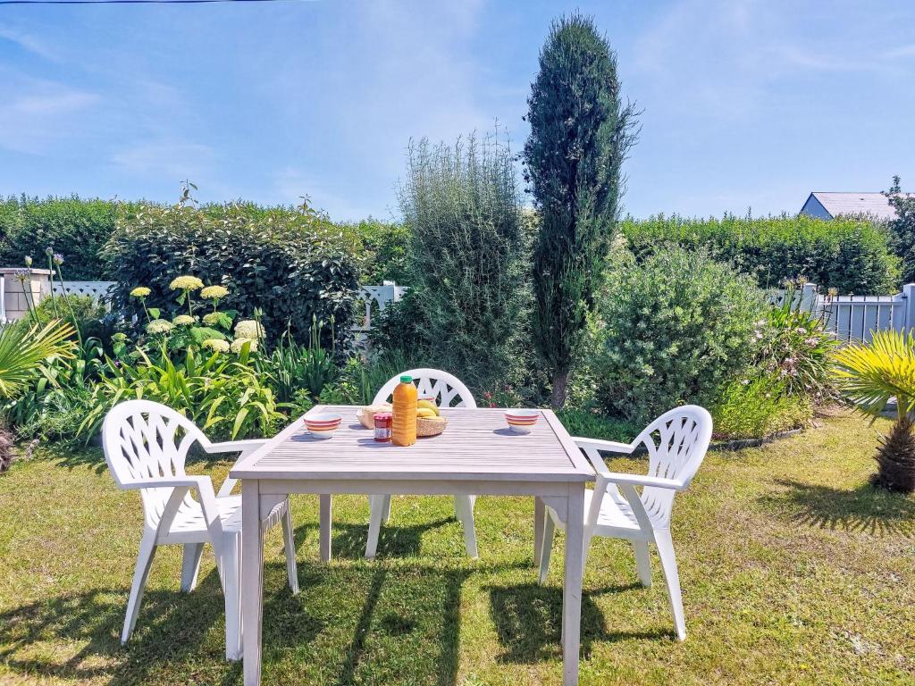 - une table blanche et deux chaises dans le jardin dans l'établissement Apartment La Note Bleue by Interhome, à Cancale