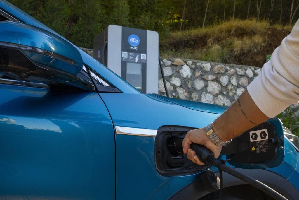 a person fueling a blue car at a gas station at Lov Faralya Adults Only in Faralya