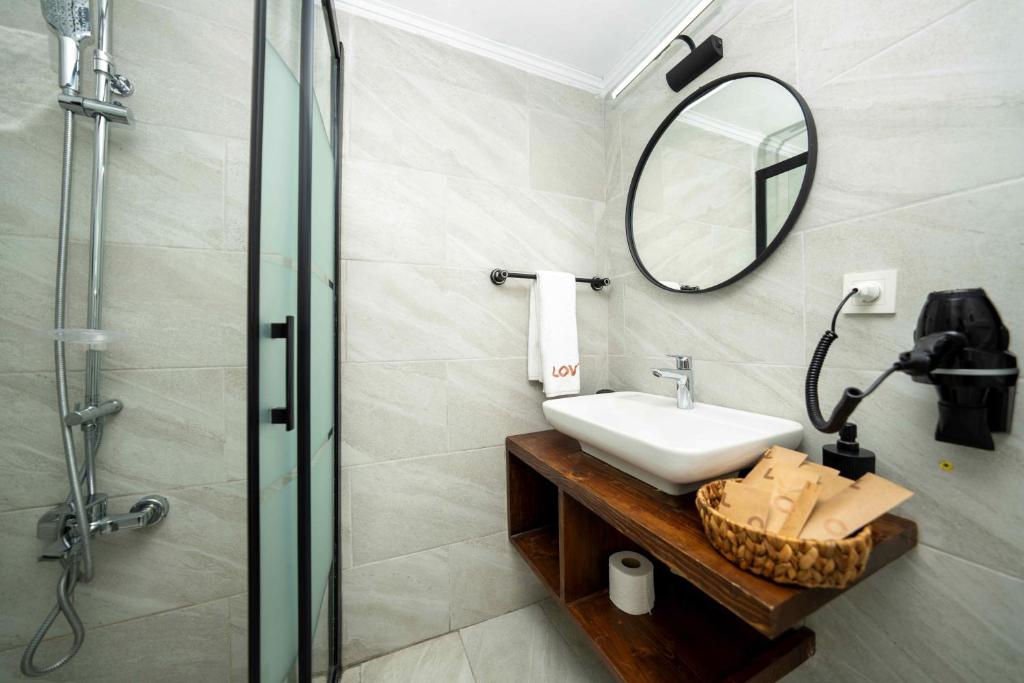 a bathroom with a sink and a mirror and a shower at Lov Faralya Adults Only in Faralya