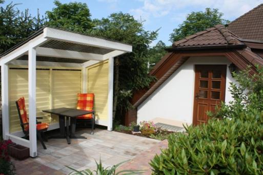 a patio with a table and a pavilion at Ferienwohnung am Fuße des Poehlberg in Königswalde