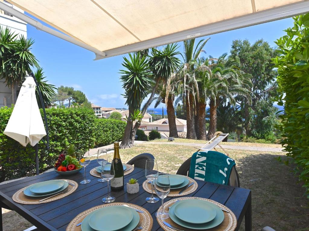 - une table bleue avec des assiettes et une bouteille de vin dans l'établissement Apartment Le Village - C2 004 by Interhome, à Agay