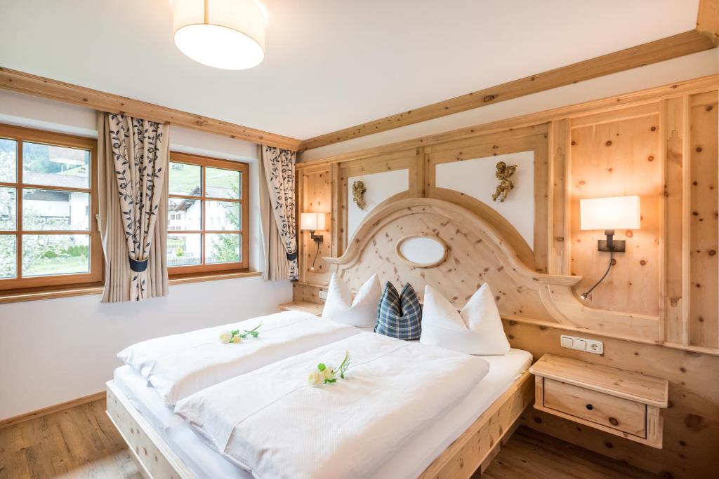 a large bed in a room with wooden walls at Residenz 111 in Holzgau