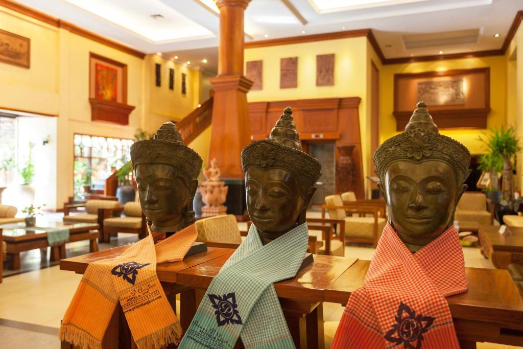 a statue of three heads sitting at tables in a restaurant at Prince Angkor Hotel & Spa in Siem Reap