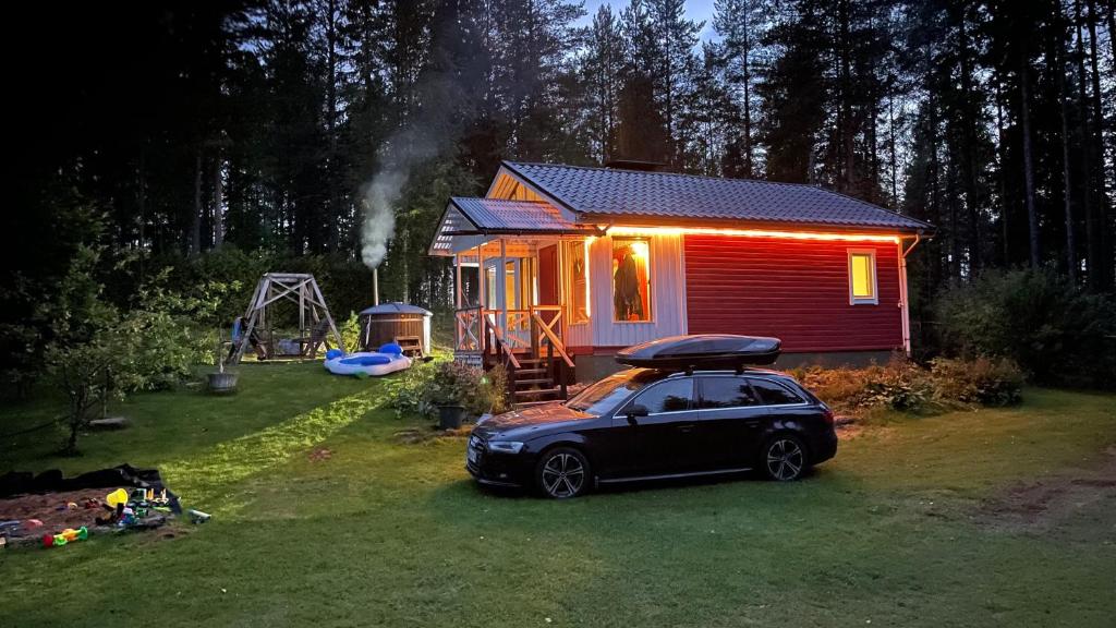 una casita con un coche aparcado delante. en Aurora cottage, en Oulu