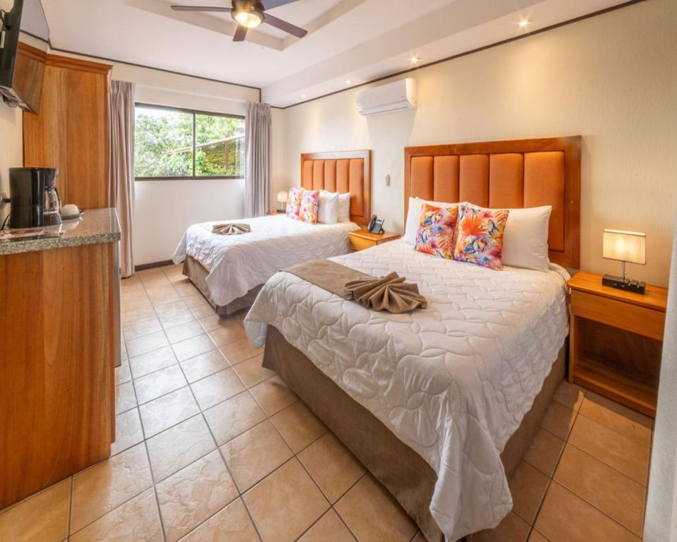 a hotel room with two beds and a kitchen at Hotel & Spa Poco a Poco - Costa Rica in Monteverde Costa Rica