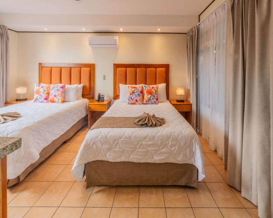 a bedroom with two beds and two lamps at Hotel & Spa Poco a Poco - Costa Rica in Monteverde Costa Rica