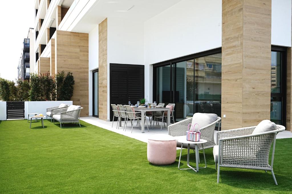 a patio with a table and chairs and grass at Lucentina Line - Be Line Group in Villajoyosa