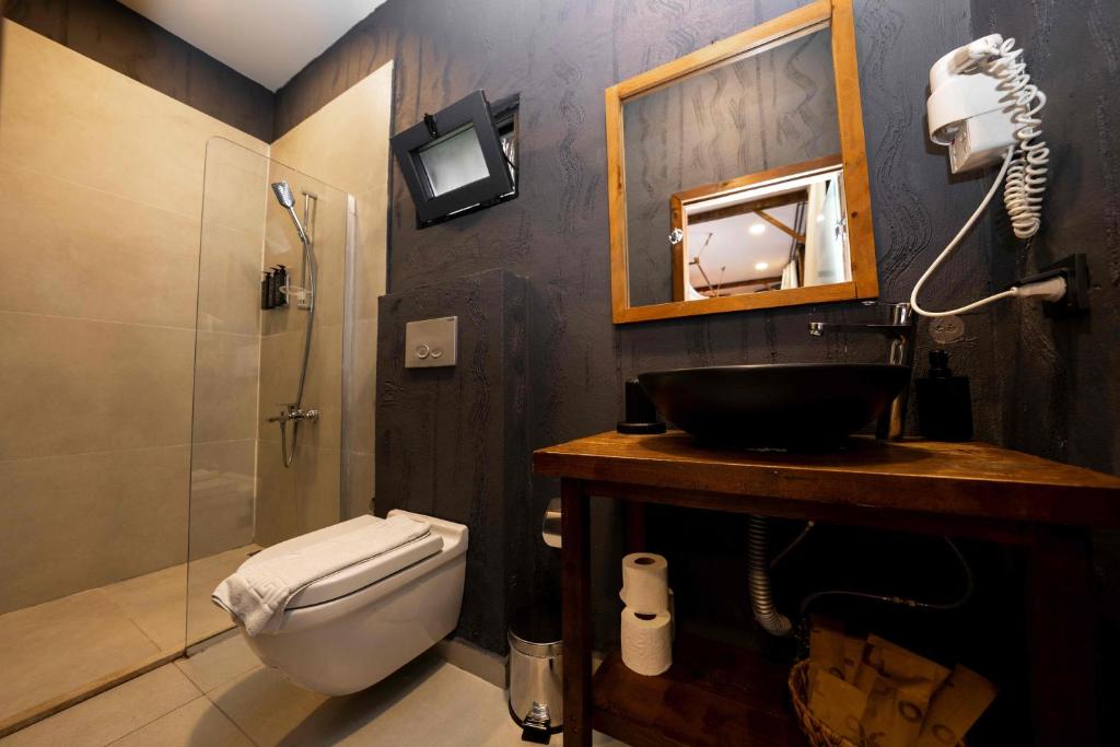 a bathroom with a toilet and a sink and a mirror at Lov Faralya Adults Only in Faralya