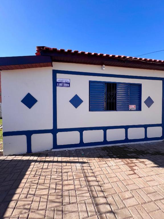 a white and blue building with a window at Suíte aconchegante no coração da Cidade in Sidrolândia