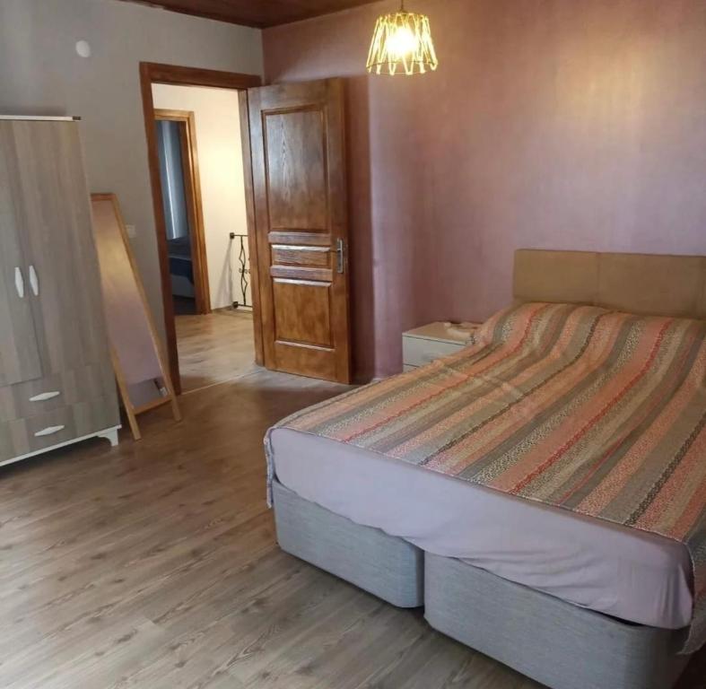a bedroom with a large bed and a wooden floor at Altun Konak in Ayvalık