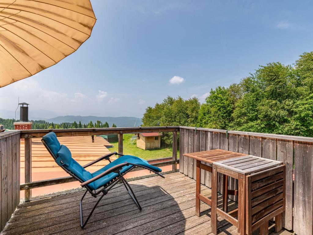a blue chair and a table on a deck at Apartment Simonhöhe-4 by Interhome in Sankt Paul