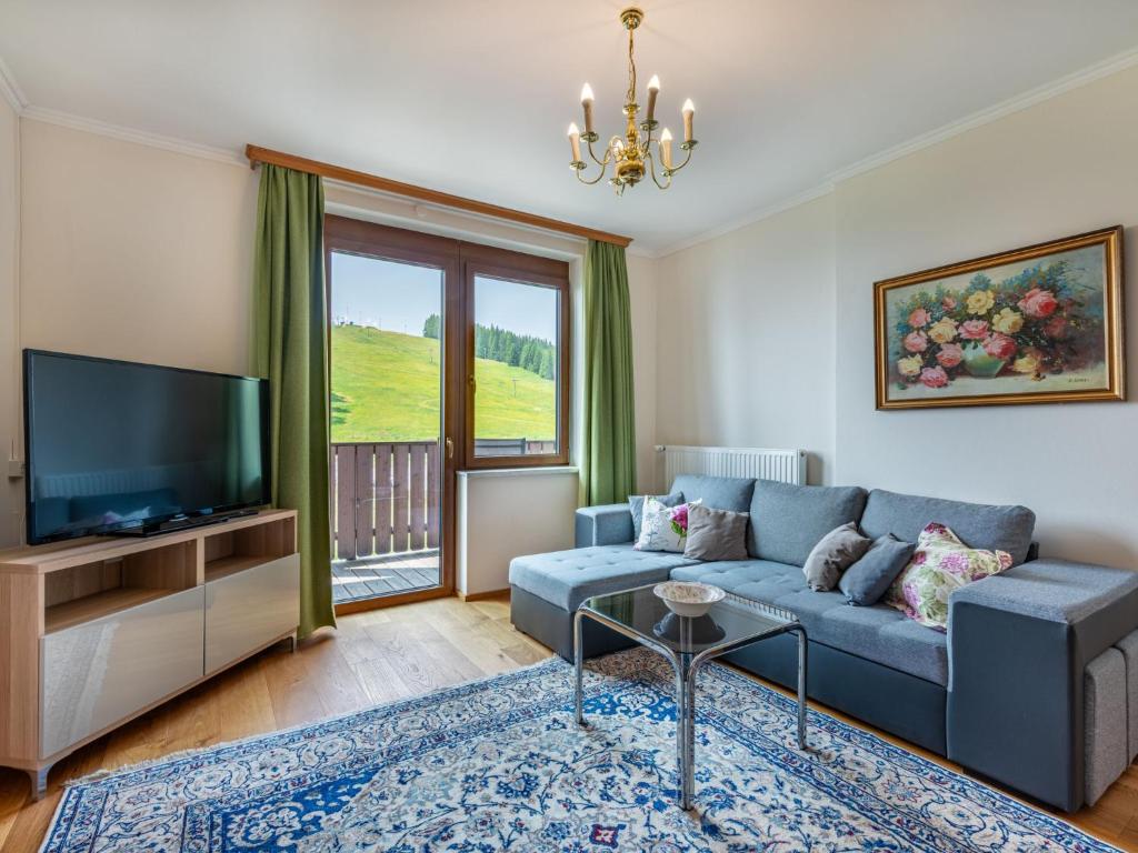 a living room with a blue couch and a television at Apartment Simonhöhe-3 by Interhome in Sankt Paul
