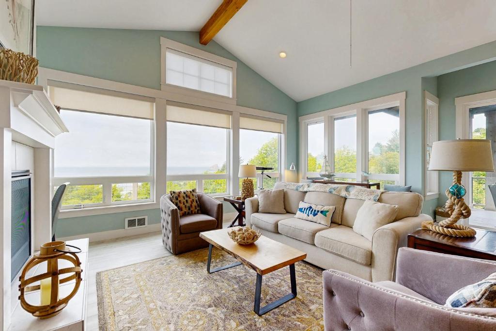 a living room with a couch and chairs and windows at Alta Vista in Pacific City
