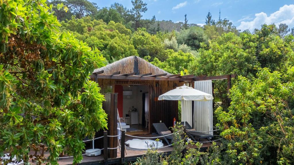 a resort with a deck with an umbrella and trees at Lov Faralya Adults Only in Faralya