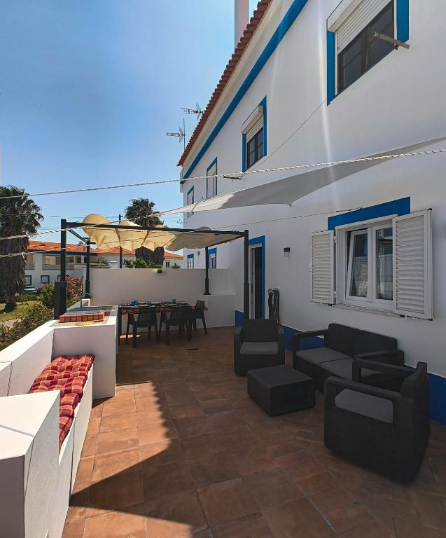 a patio with couches and a table on a building at Casa Velha de Vila Nova in Vila Nova de Milfontes