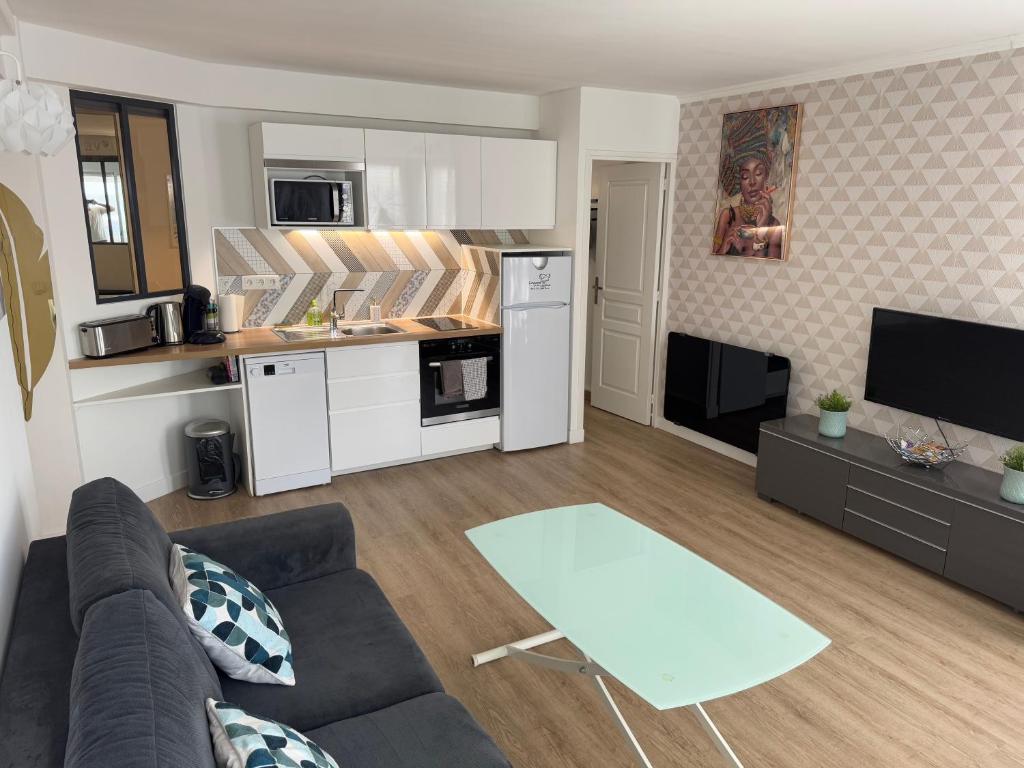 un salon avec un canapé et une cuisine dans l'établissement Appartement 40 m2 climatisé au centre ville de LGM, à La Grande Motte