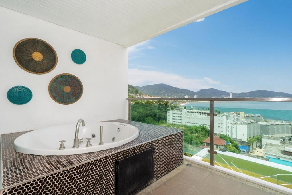 芭东海滩Private sea view apartment with jacuzzi at Baycliff的设有带水槽的浴室,享有海景