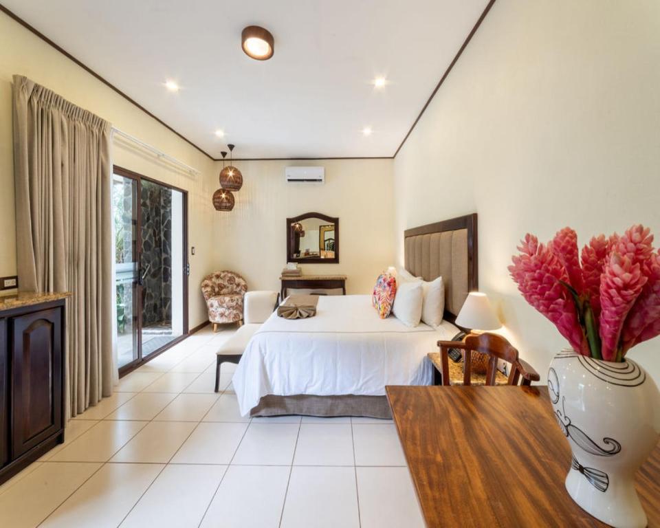 a large bedroom with a bed and a table at Hotel & Spa Poco a Poco - Costa Rica in Monteverde Costa Rica