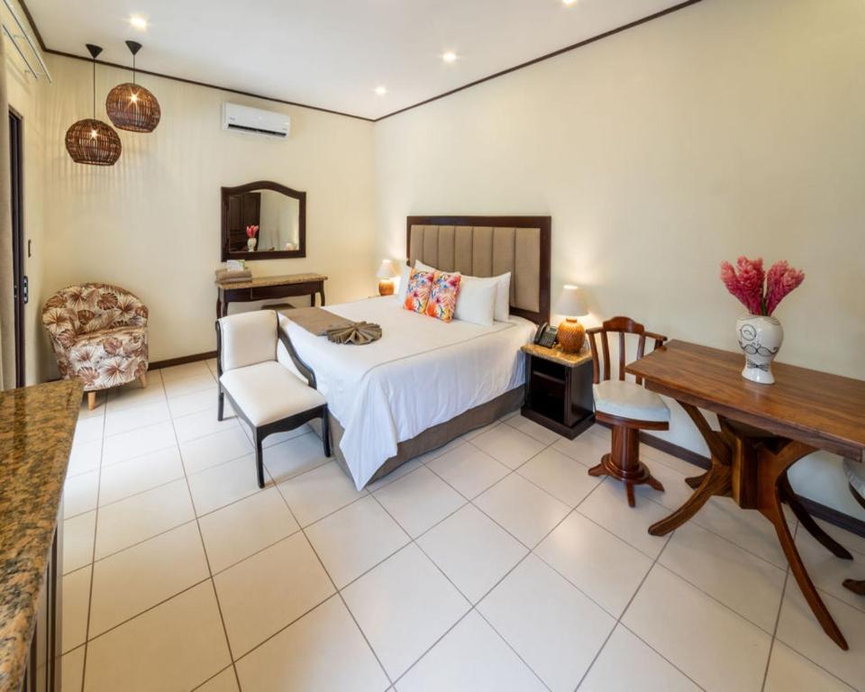 a bedroom with a bed and a table and a desk at Hotel & Spa Poco a Poco - Costa Rica in Monteverde Costa Rica