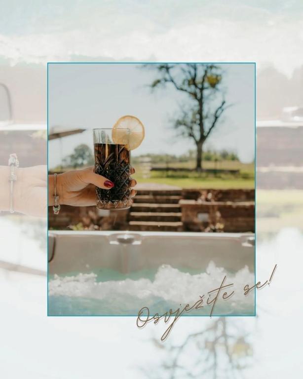 a hand holding a glass filled with bees at Ruralna kuća za odmor - Bitunjac in Levanjska Varoš