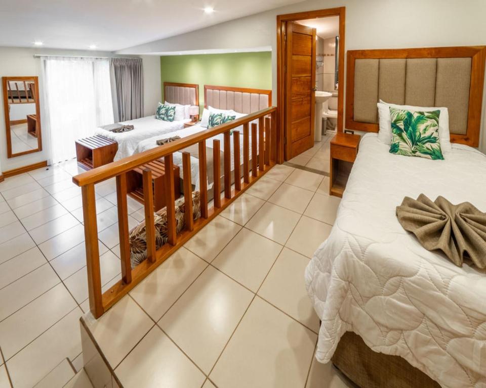 a bedroom with two beds and a bathroom at Hotel & Spa Poco a Poco - Costa Rica in Monteverde Costa Rica