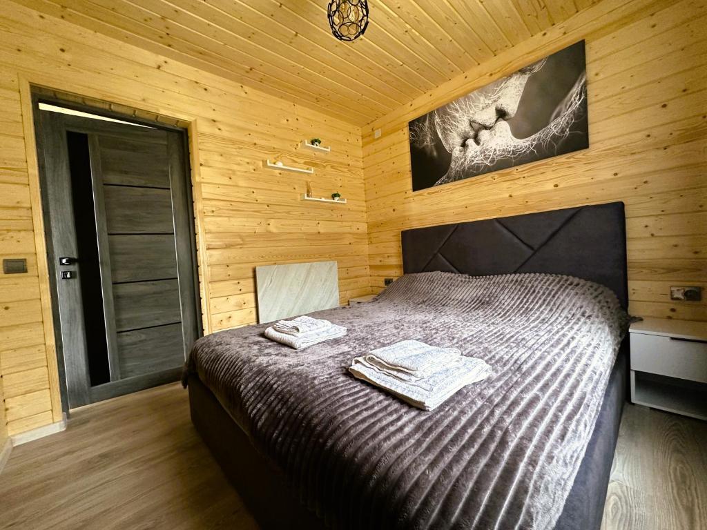 a bedroom with a bed with two towels on it at Котедж Forest house in Verkhovyna