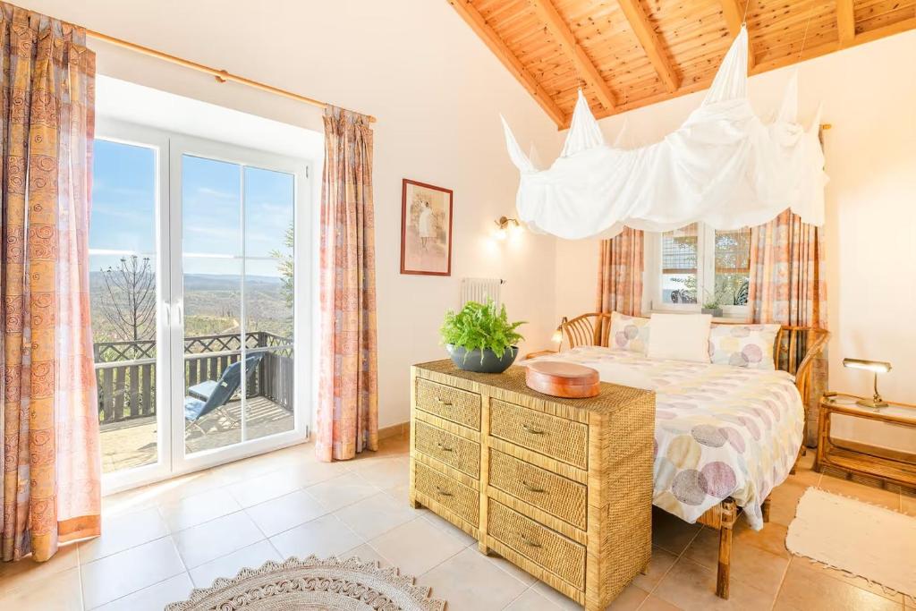 una camera da letto con un letto e una grande finestra di CASA PAVÃO (SALGADINHO - SELÃO DA EIRA) a São Teotónio