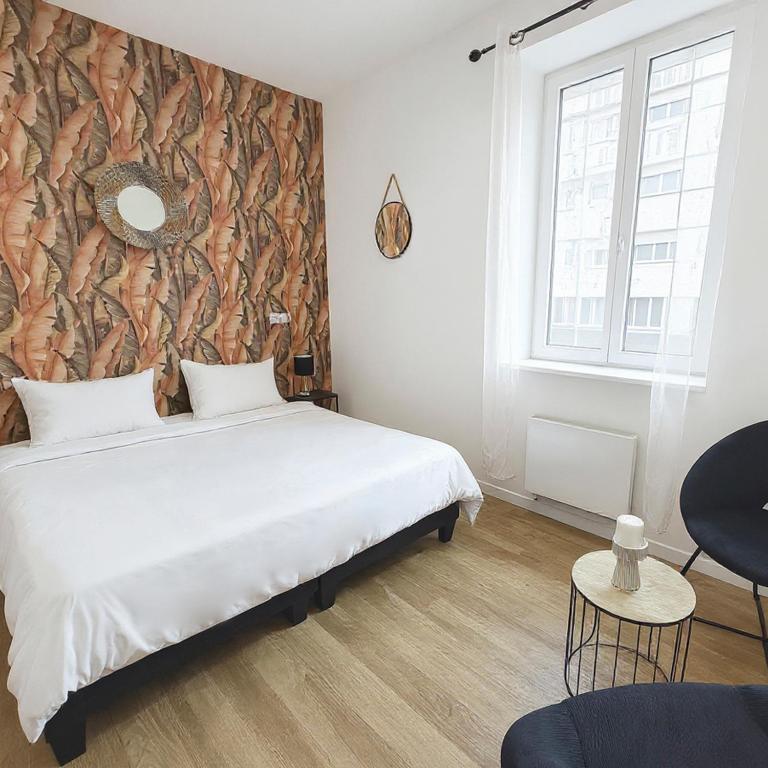 - une chambre avec un lit et un mur orné d'une fresque murale dans l'établissement Charmant studio rénové à Roubaix, à Roubaix