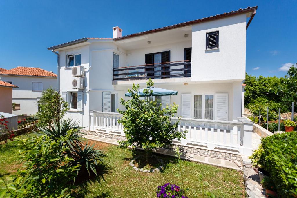 a white house with a garden in front of it at Villa Rosi in Krk