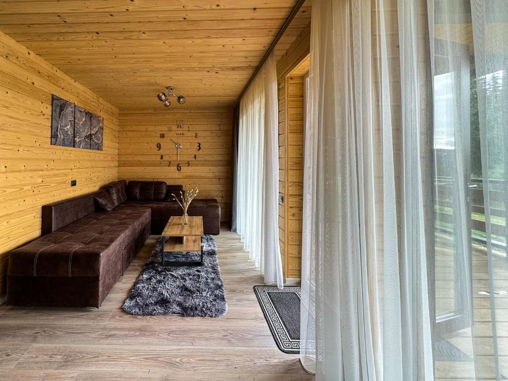een woonkamer met een bank en een tafel bij Котедж Forest house in Verkhovyna