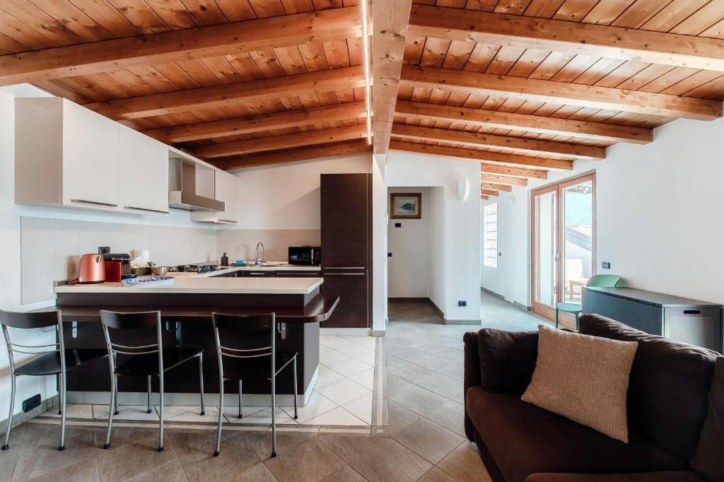 a kitchen and living room with wooden ceilings at La Colonghera by Quokka 360 - flat on Lake Como in Carate Urio