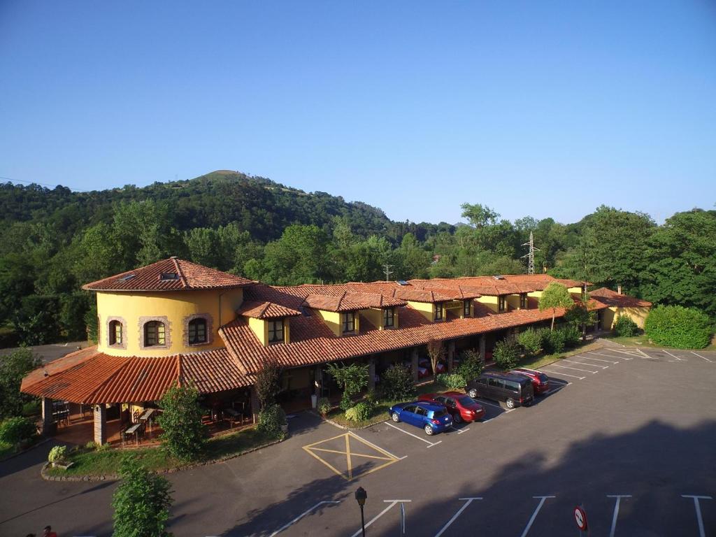 an aerial view of a hotel with cars parked in a parking lot at Hotel El Bricial in Soto de Cangas