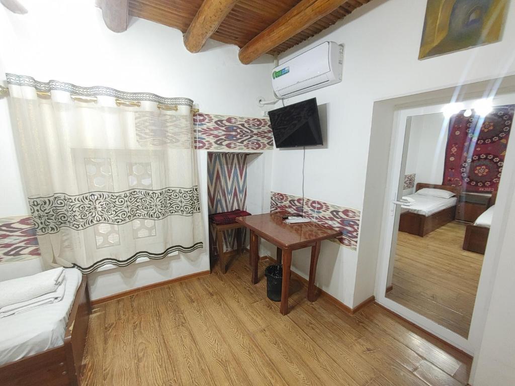 une petite chambre avec un bureau et une chambre avec un lit dans l'établissement Ohun saray Historical Museum hotel XIX century Best cheap in old sity Bukhara boasts a wealth of historical monuments, reflecting its rich history as a major Silk Road city, à Boukhara