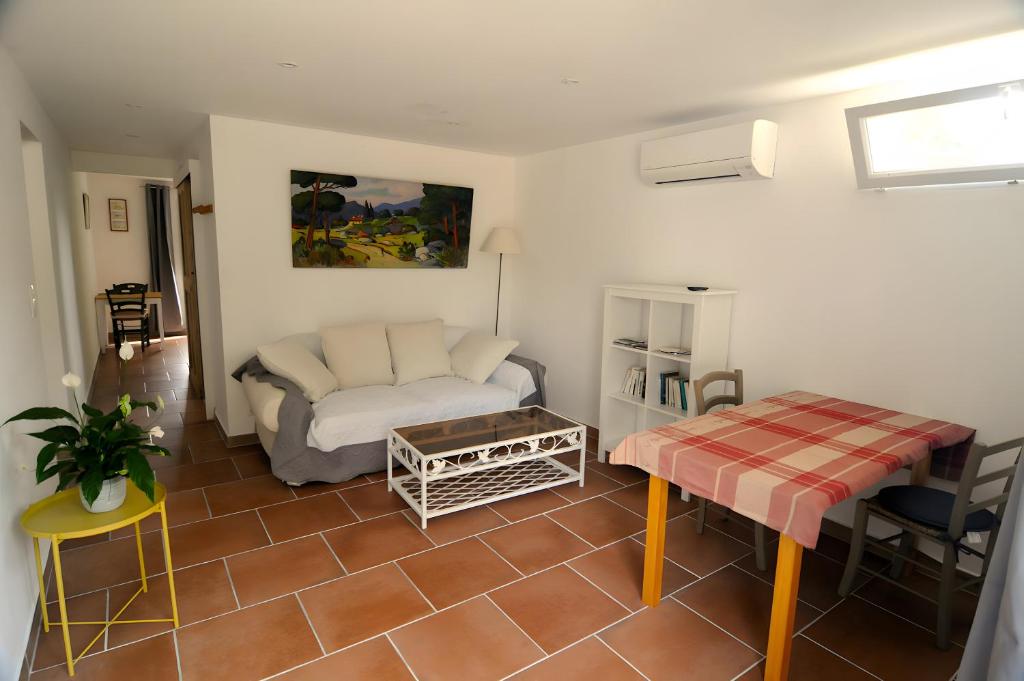 un soggiorno con un divano e un tavolo di Le Petit Pont a LʼIsle-sur-la-Sorgue