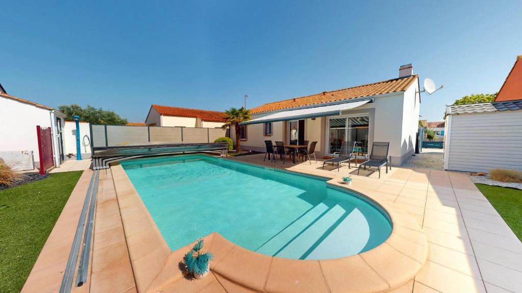 a swimming pool in the backyard of a house at Palm Cornue avec piscine privative in Saint-Gilles-Croix-de-Vie