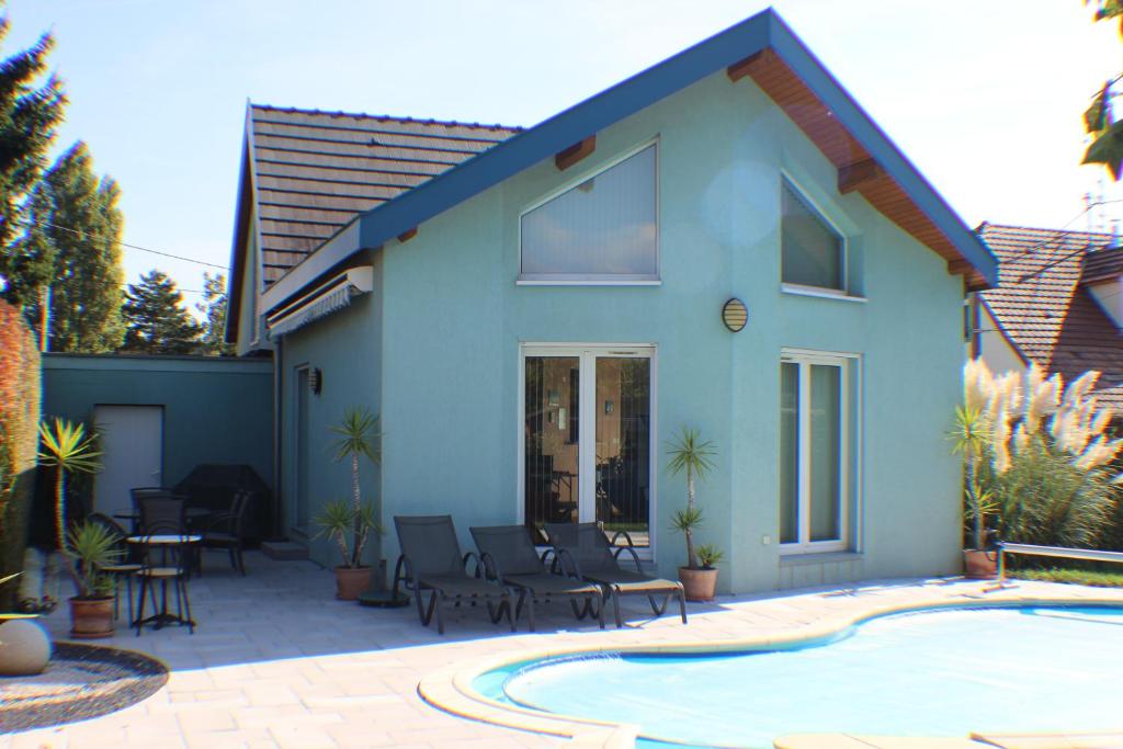 Cette maison bleue dispose d'une terrasse et d'une piscine. dans l'établissement Très jolie maison avec piscine, à Soultz-Haut-Rhin