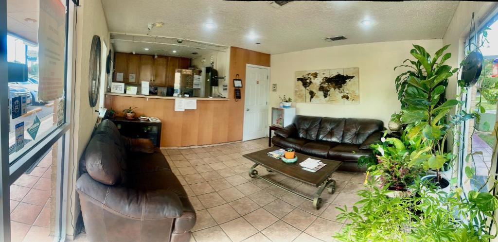 a living room with a leather couch and a table at Hallmark Inn And Suites in Killeen