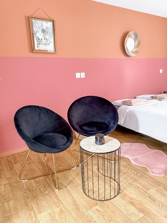 - deux chaises dans une chambre avec un lit et une table dans l'établissement Studio lumineux et cosy, à Roubaix