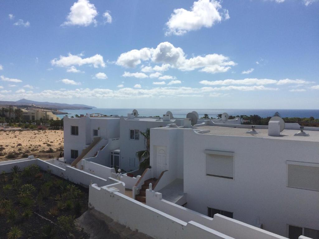 a view of a white house and the beach at 3C Jardín del Río in Costa Calma