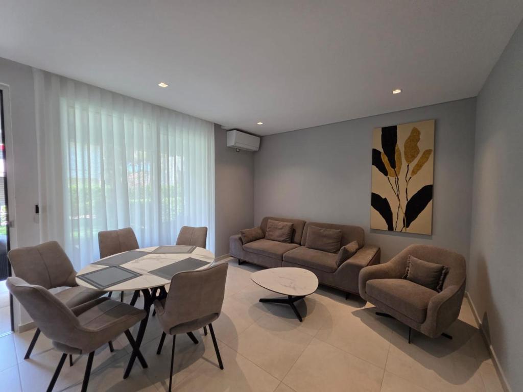 a living room with a table and chairs and a couch at Blue Harmony in Lalzit Bay