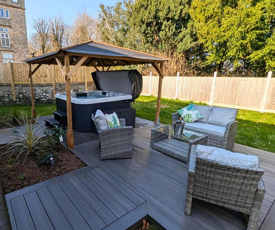 a patio with a grill and a table and chairs at Eden Grove 2 Bed Holiday Retreat With Hot Tub in Kirkby Thore