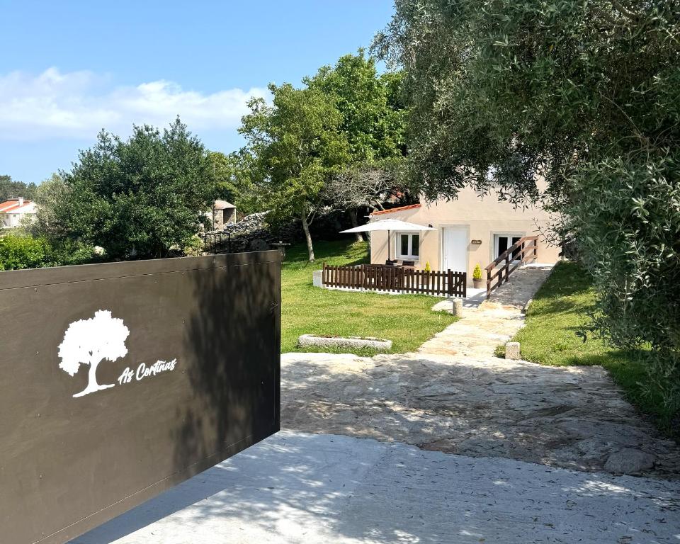 a gate to a house with a tree on it at As Cortiñas, casa vacacional completa en Laxe 