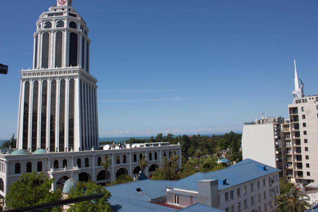 a large building with a tall tower in a city at Apartment Archil Batumi in Batumi